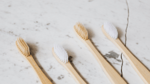 4 wood toothbrushes laying on a countertop